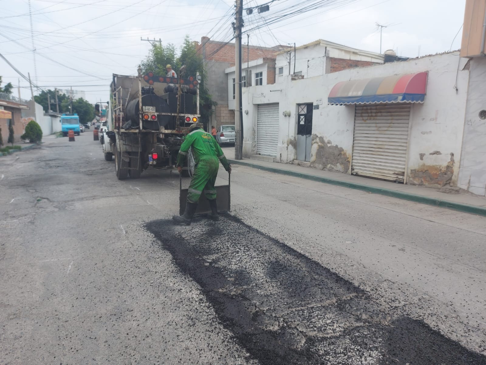 Trabajador realiza labores de bacheo en una calle de la colonia General I. Martínez como parte del programa Enchúlame la Colonia.