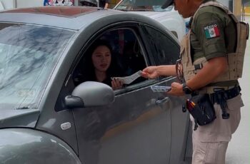 Elemento de la Guardia Civil Estatal entrega material informativo a una automovilista durante una jornada preventiva en Matehuala.