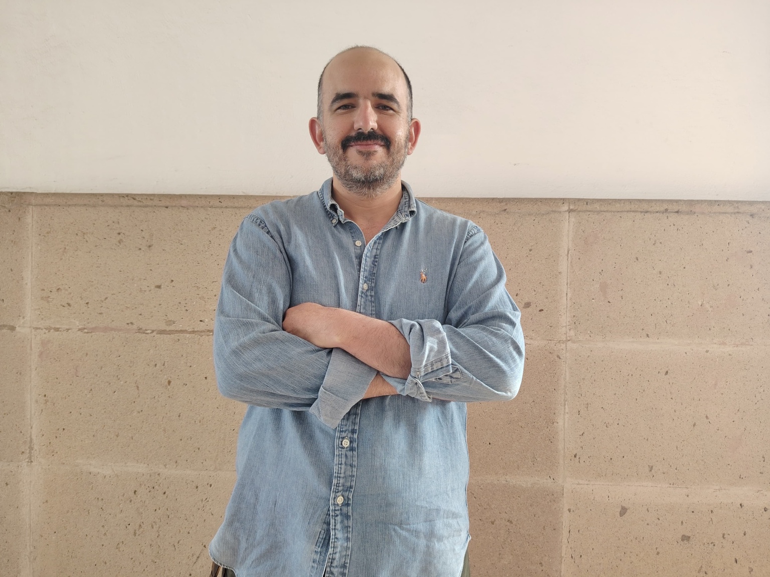 José Antonio Motilla Chávez, investigador de la UASLP, frente a un muro claro