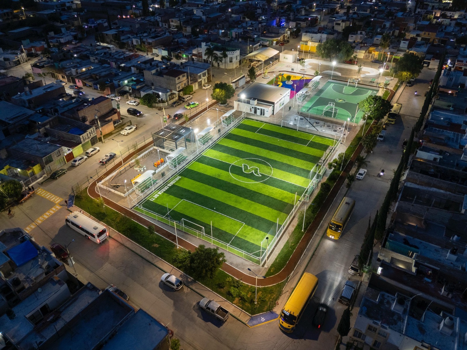 Vista aérea nocturna de un parque urbano con cancha deportiva en Soledad de Graciano Sánchez