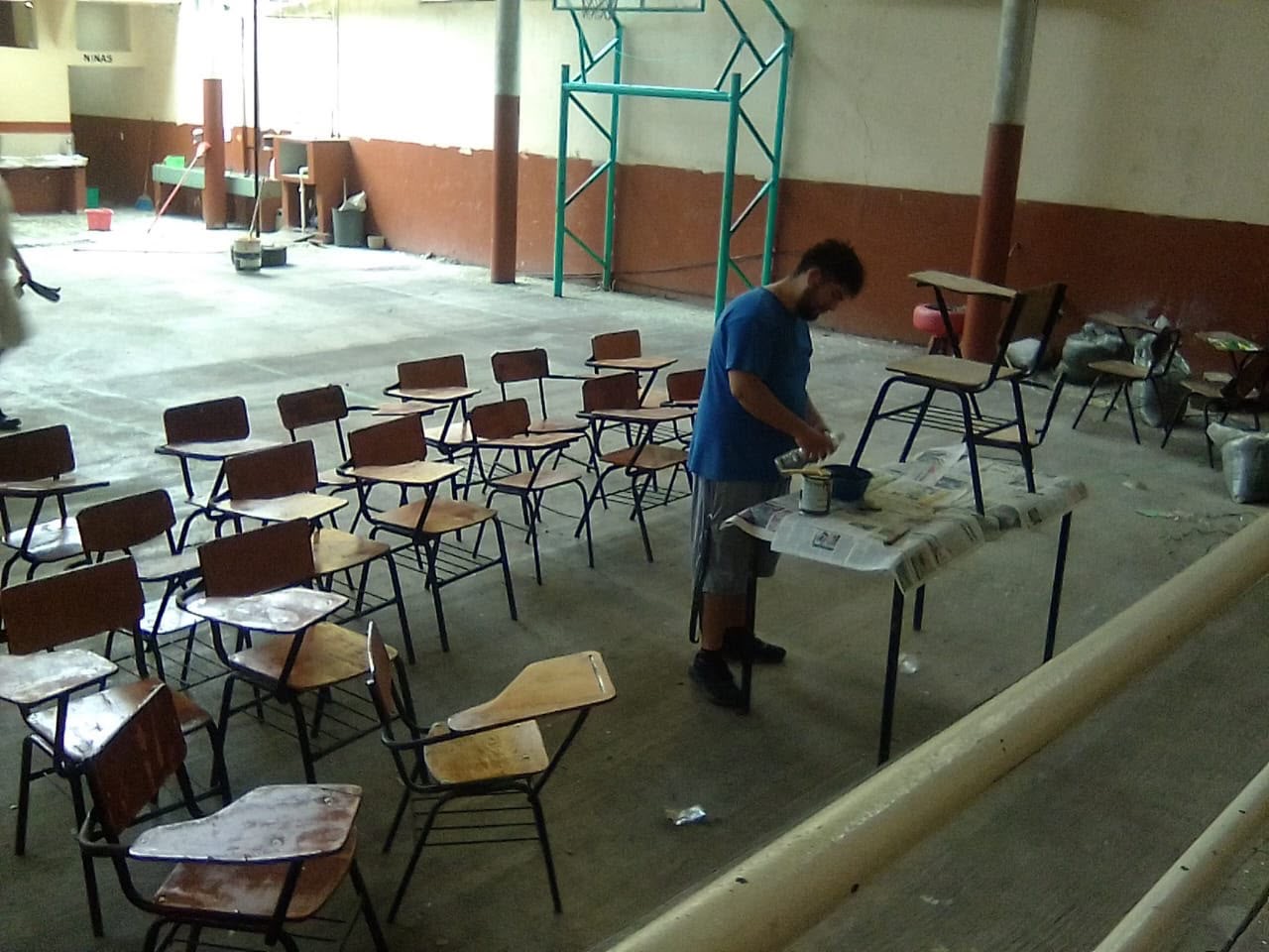 Persona realiza trabajos de mantenimiento en mobiliario de un plantel educativo del SEER durante el receso escolar