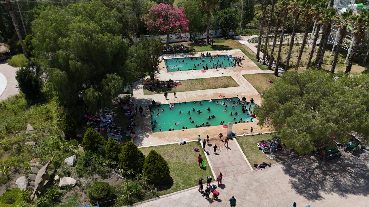 Vista aérea de familias en albercas y áreas verdes de DinOasis Aqua Park dentro del Parque Tangamanga I.