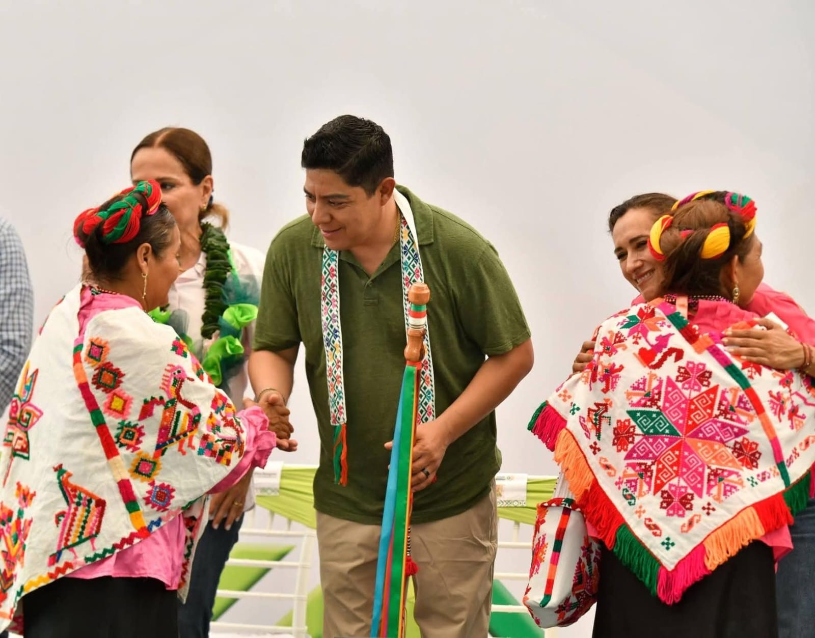 Ricardo Gallardo Cardona saluda a mujeres con vestimenta tradicional durante un acto público sobre comunidades indígenas en San Luis Potosí.