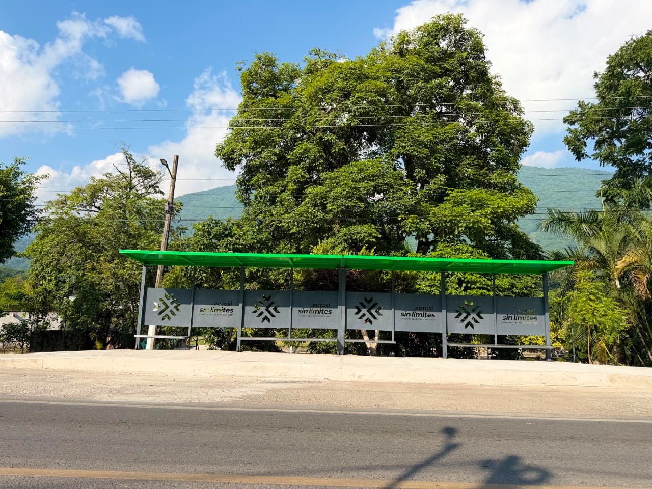 Parador de RedMetro Riviera Huasteca en una vialidad rodeada de vegetación, como parte de la infraestructura de transporte gratuito en la región Huasteca.