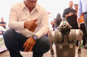 Ricardo Gallardo Cardona junto a un perro robot durante la presentación de tecnología de seguridad para la FENAPO 2026.