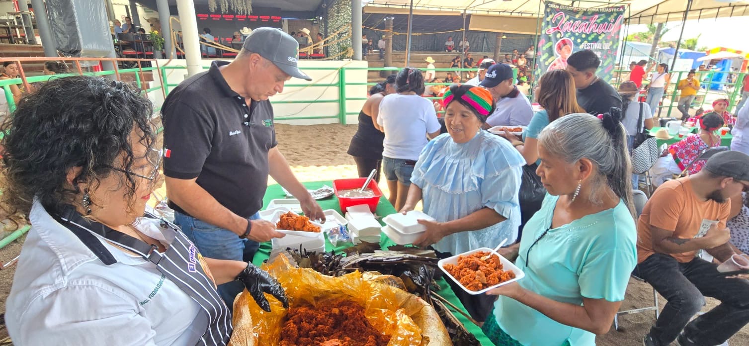 Cocineras y productores sirven zacahuil huasteco durante una degustación gratuita en Tierra Ganadera de la Feria Nacional Potosina 2026.