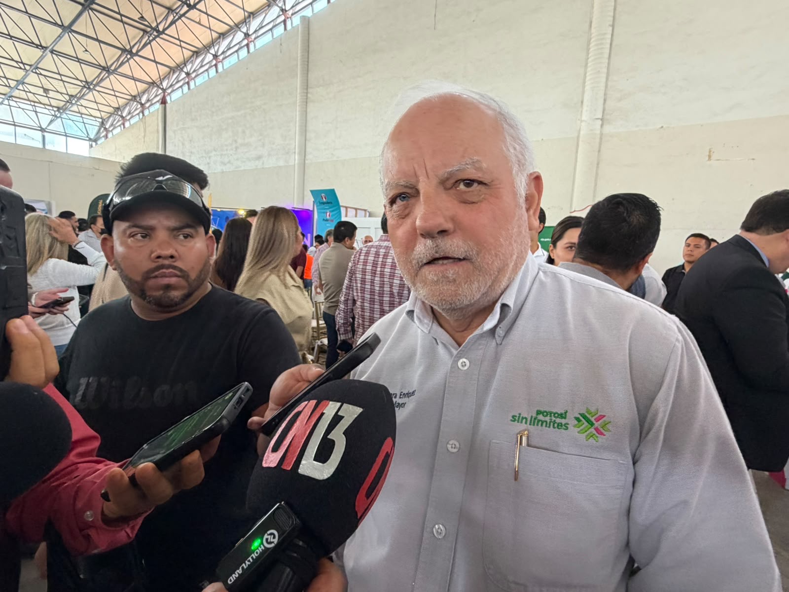 Funcionario estatal atiende a representantes de medios de comunicación durante un evento público.