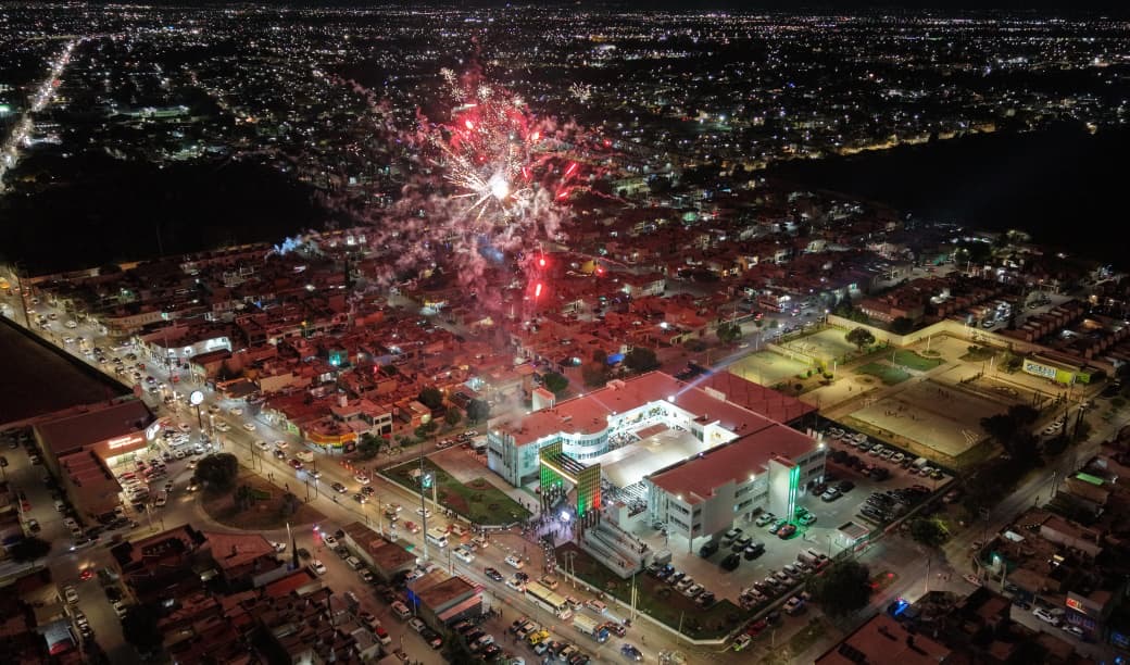 Vista aérea nocturna de Soledad de Graciano Sánchez durante la presentación del Segundo Informe de Resultados, con fuegos artificiales sobre la zona urbana.