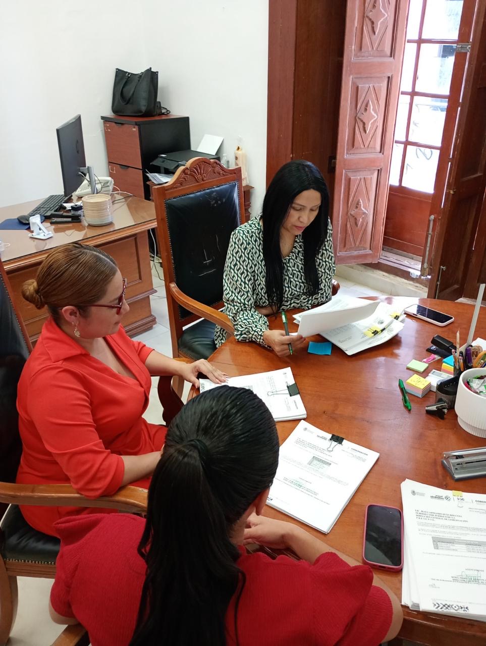 Personal de la Dirección General de Gobernación revisa documentación administrativa en una oficina.