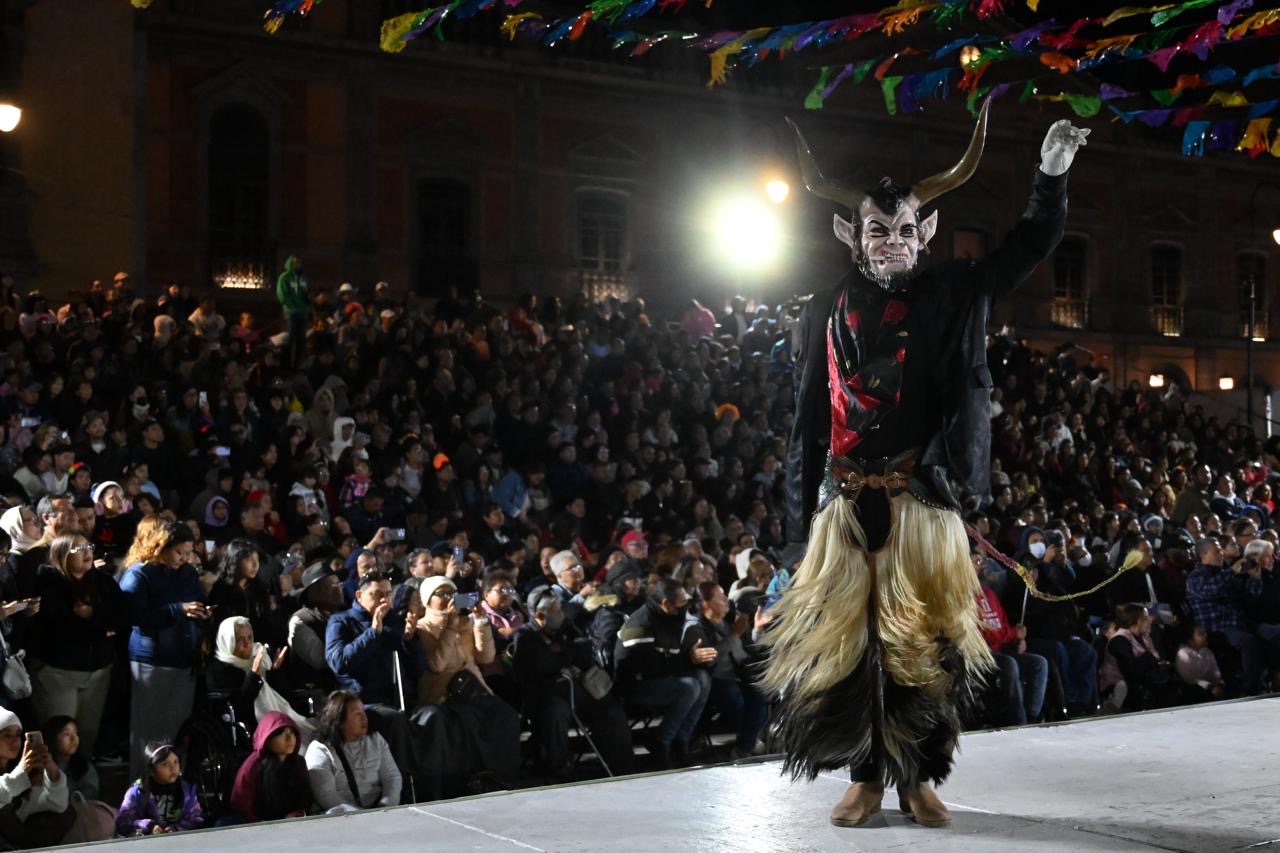 Participante con máscara de cuernos y vestuario tradicional durante el Desfile Monumental de Xantolo, ante numerosas familias reunidas en San Luis Potosí.