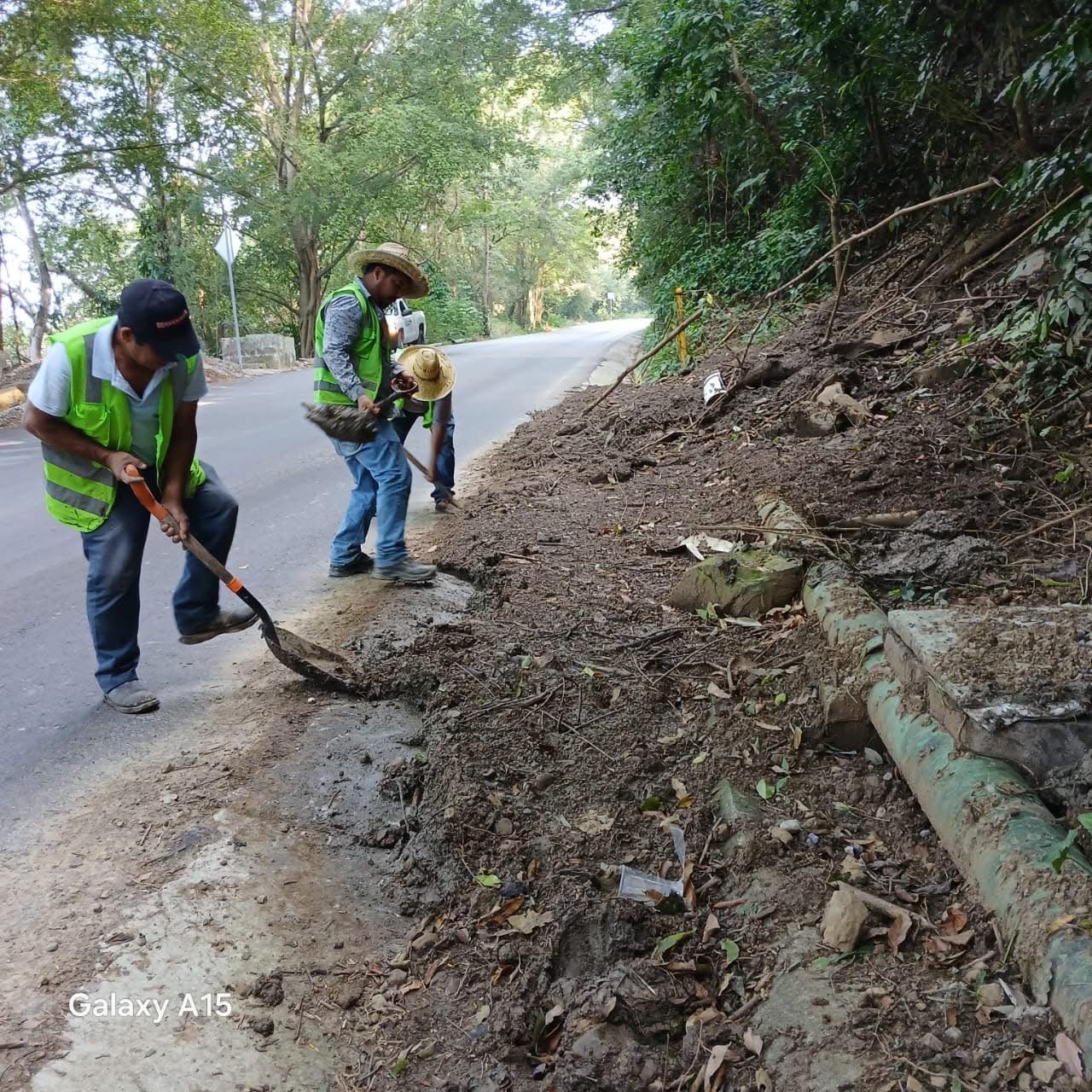 Trabajadores realizan labores de limpieza y retiro de material junto a una carretera durante la temporada de lluvias en San Luis Potosí.