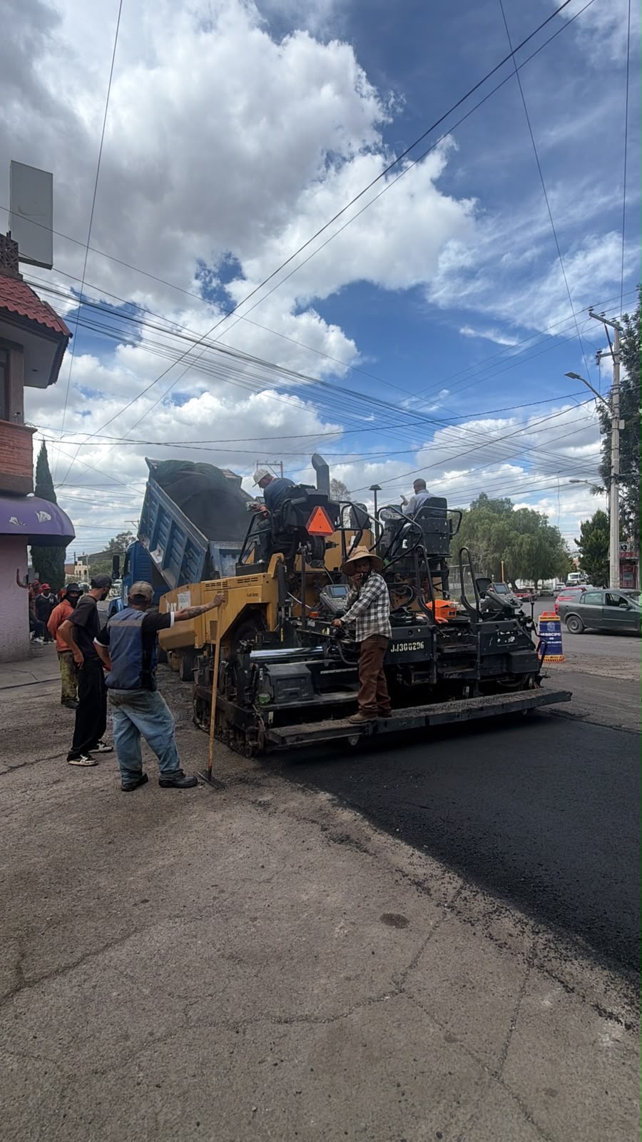 Personal y maquinaria realizan trabajos de pavimentación asfáltica en una calle de San Luis Potosí.
