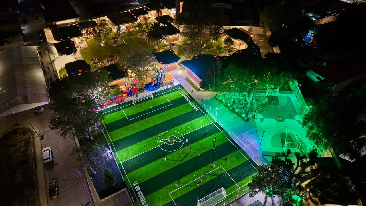 Vista aérea nocturna del nuevo Centro Integral de Capacitación y Deporte en la colonia San Francisco de Soledad, con canchas iluminadas