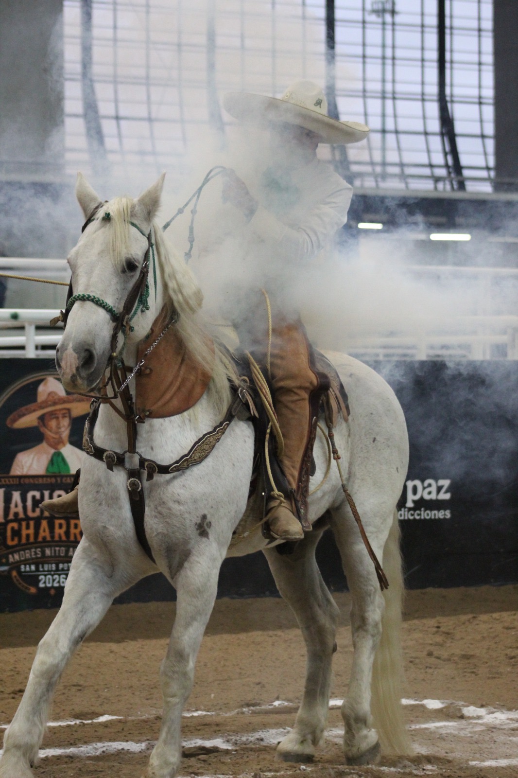 Jinete charro a caballo blanco durante una competencia de charrería en la Arena Potosí.