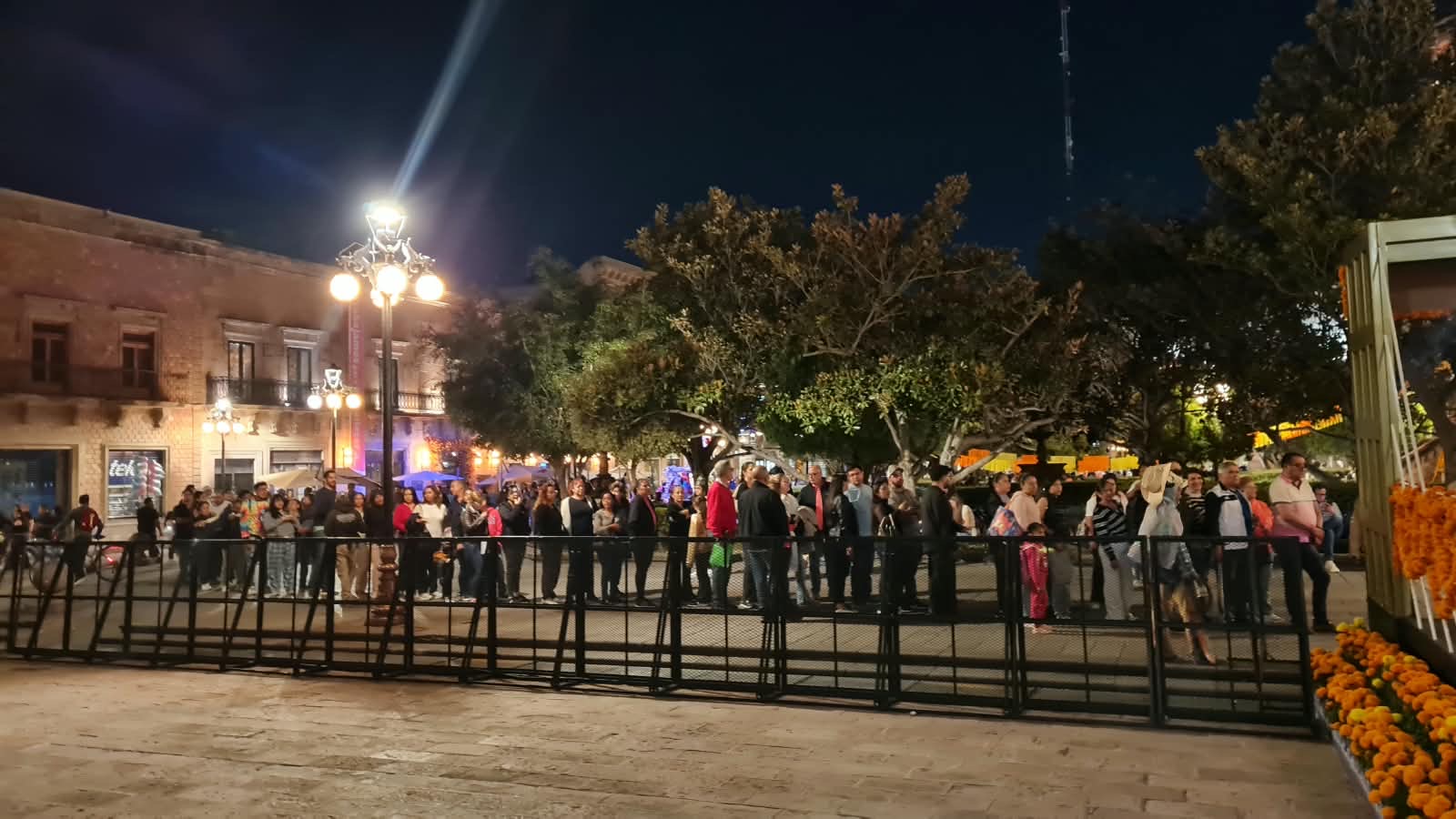 Fila de visitantes frente a Palacio de Gobierno de San Luis Potosí durante la exhibición del altar monumental de Día de Muertos.