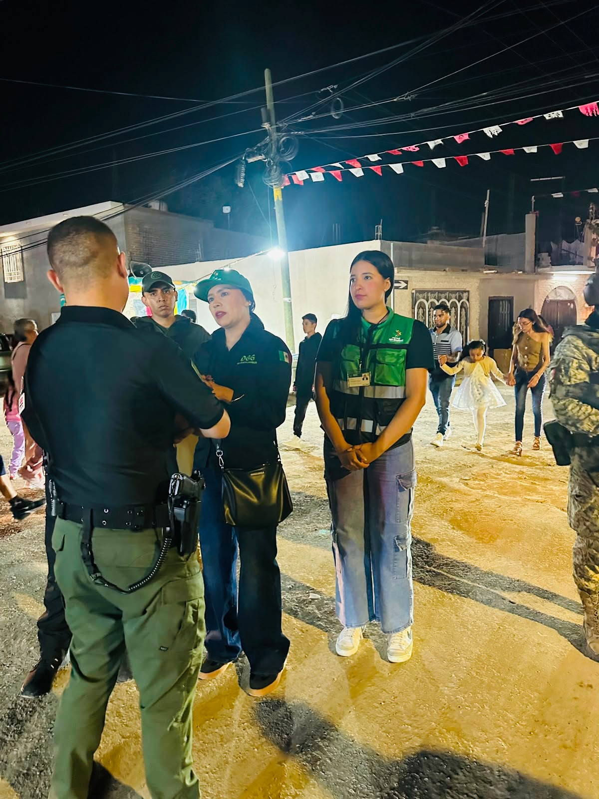 Personal de Gobernación y elementos de seguridad durante un recorrido nocturno de supervisión en una zona de celebraciones de Día de Muertos.